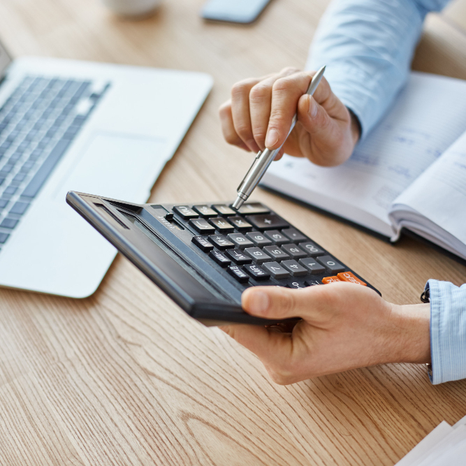 Manos utilizando calculadora con bolígrafo